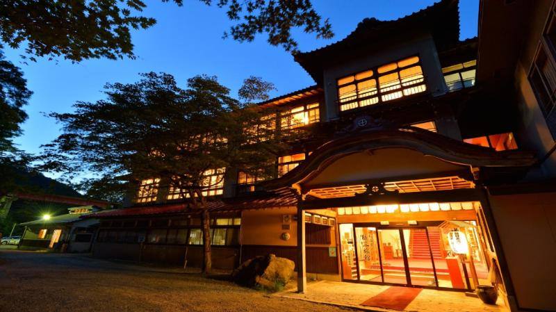 Namari Onsen Fujisan Ryokan wooden exterior and illuminated entrance at dusk