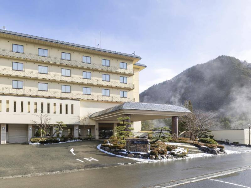 Ooedo Onsen Monogatari hotel entrance with wooded hills behind it