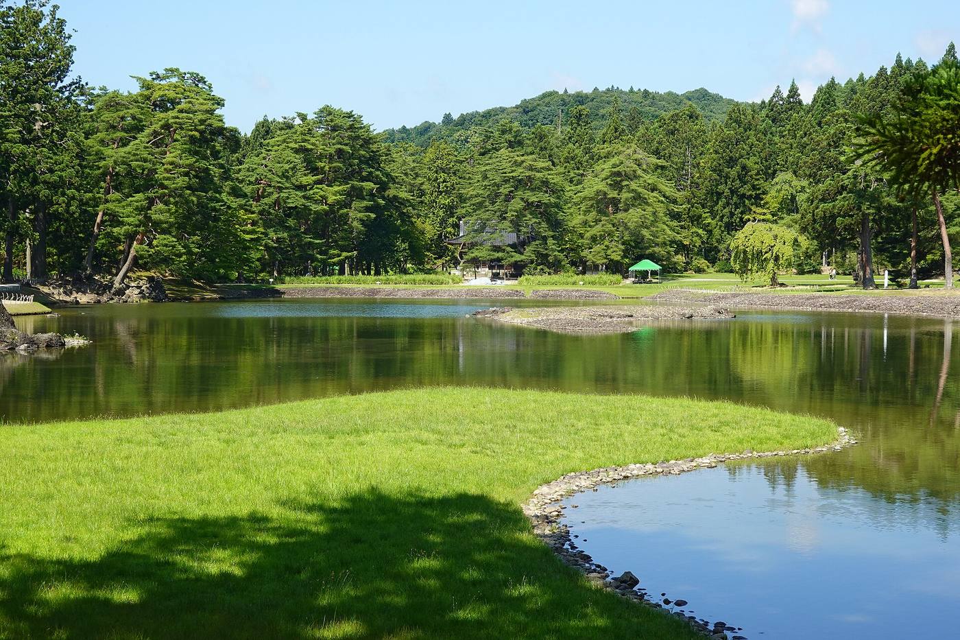 Motsuji’s pond garden reflecting leafy trees in summer.