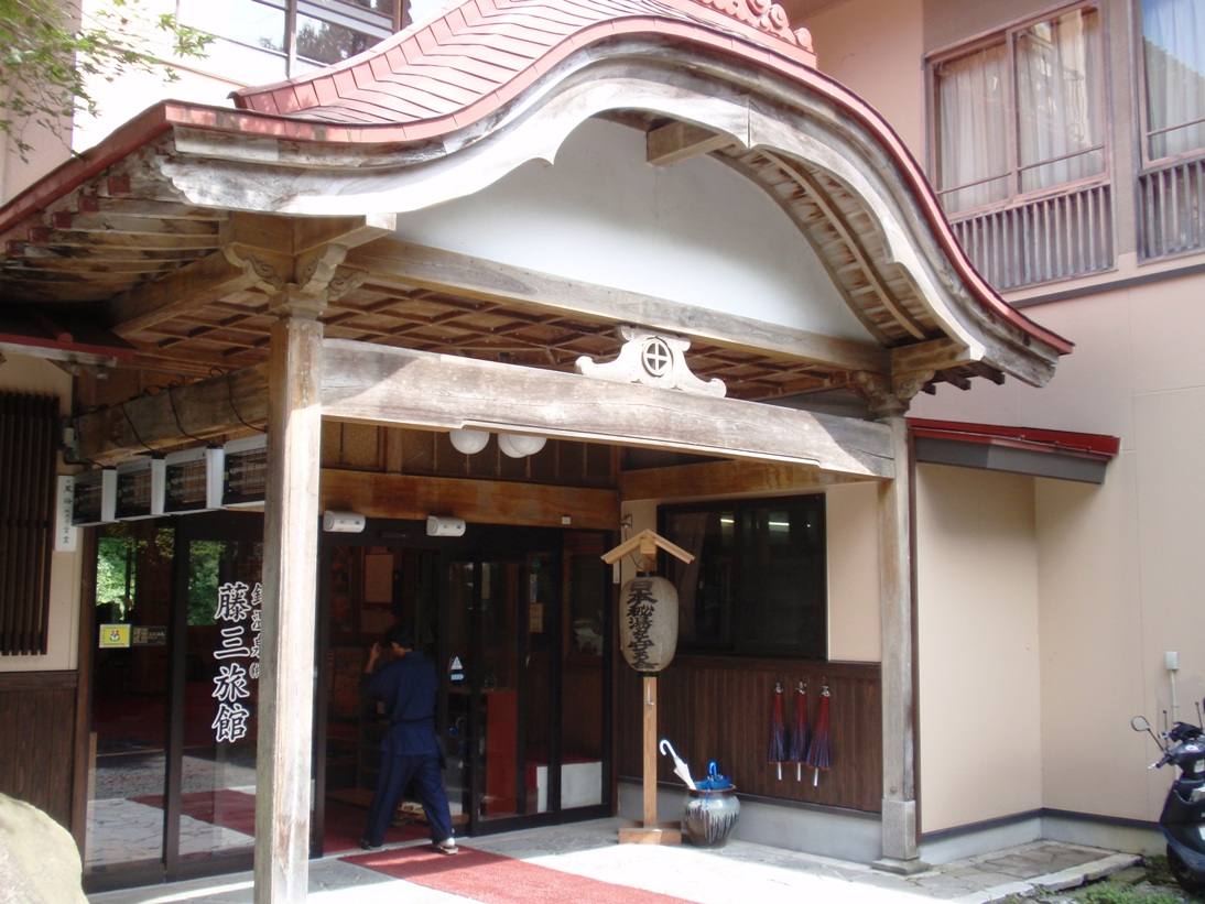 The curved entrance canopy and doors of Fujisan Ryokan at Namari Onsen.