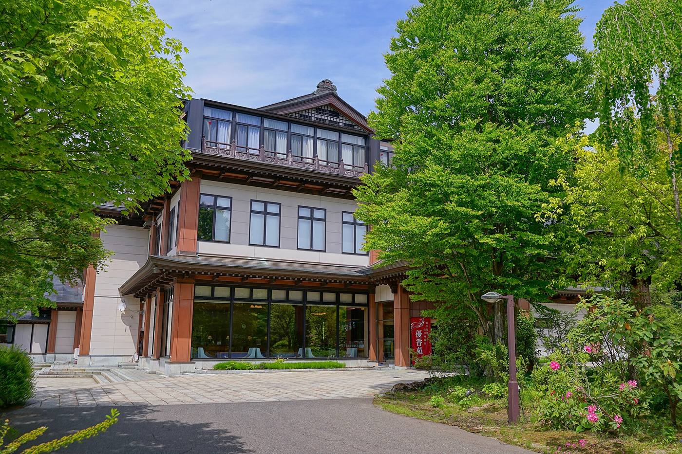 Yukaen’s timber-framed facade among leafy trees at Yamanokami Onsen.